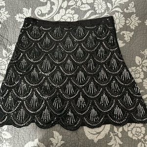 Black sequin skirt with scalloped bottom.